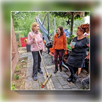 Joke en Hester van biodiversiteitsgroep in gesprek met bewoner Ilse in de tuin nadat de tegels zijn gewipt en de plantjes geplant.