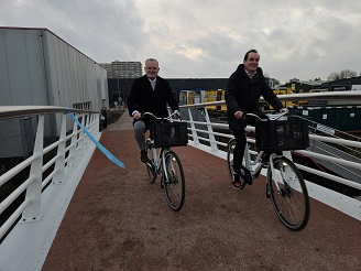 Wethouder Nijssen en wethouder Slegers fietsen over de nieuwe brug