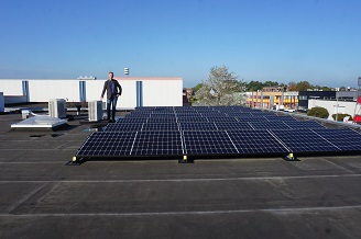 Erwin Hooijschuur op dak met zonnepanelen