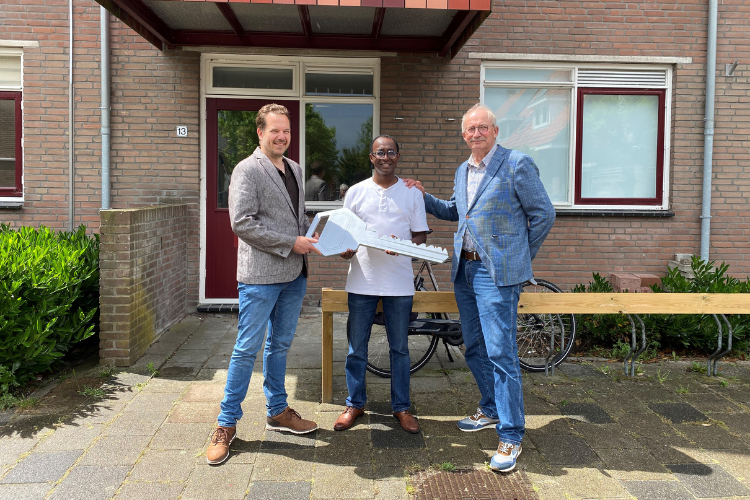 Bestuurder WOV Rudi van Aert overhandigt symbolisch de sleutel aan Ahmed Ali directeur van DWQ. Rechts: wethouder Eelco Taams